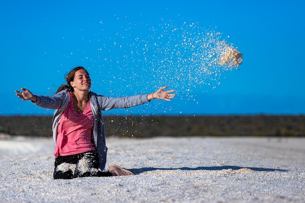 A beautiful girl plays with seashells on the famous shell beach in western australia at sunset