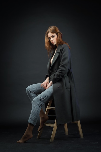 A beautiful girl poses in a dark studio