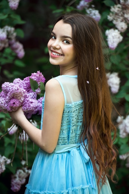사진 라일락 정원에서 포즈를 취하는 아름 다운 소녀