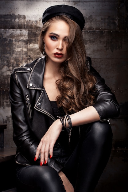 Photo beautiful girl posing on a leather jacket