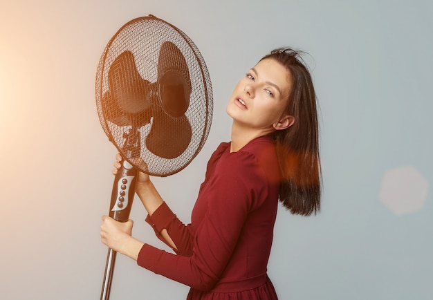 Foto bella ragazza in posa con un fan