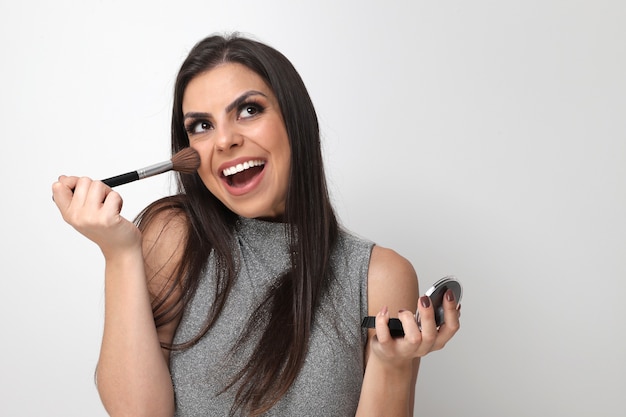 Beautiful girl putting on make up