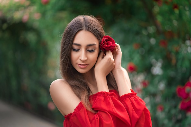 Beautiful girl in a red dress with a rose