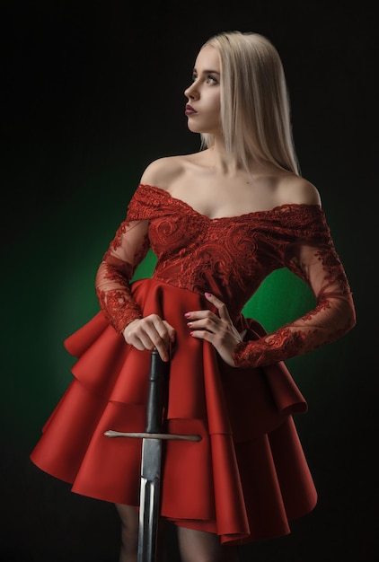 Beautiful girl in red dress with sword