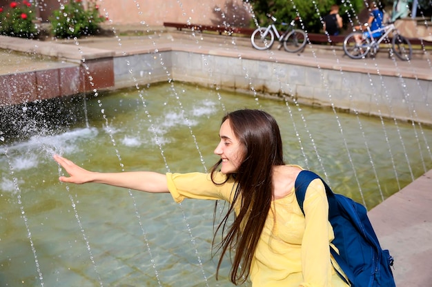 Foto bella ragazza che si rilassa con una fontana