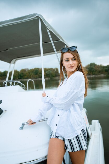 Beautiful girl resting on the yacht. Yachting. Luxury lifestyle. Beautiful woman in sunglasses on head and bikini relaxing on yacht. Luxurious life for woman enjoying travel, summer vacation