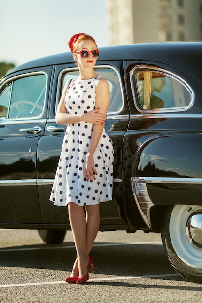 Photo beautiful girl in retro style and a vintage car