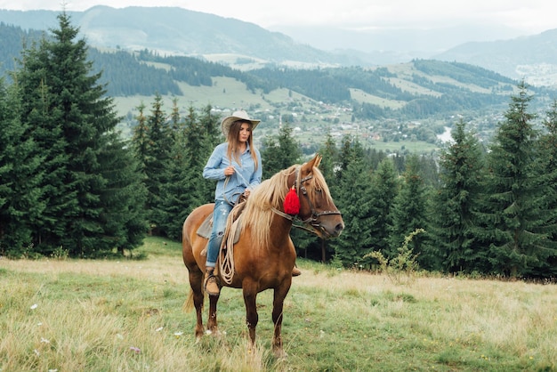 Beautiful girl riding a horse in countryside and mountains .