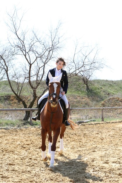 Beautiful girl riding a horse outdoors