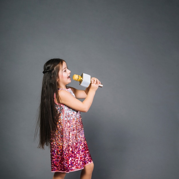 Beautiful girl in sequin dress signing song with microphone