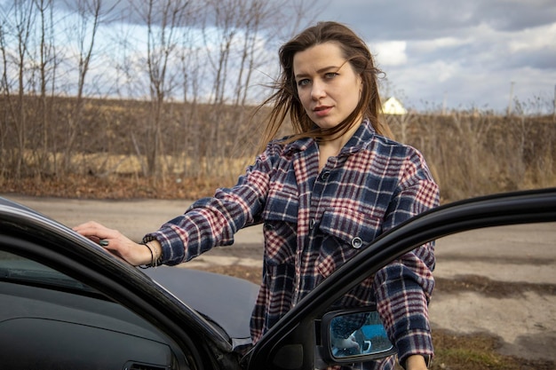 Beautiful girl in a shirt near the car