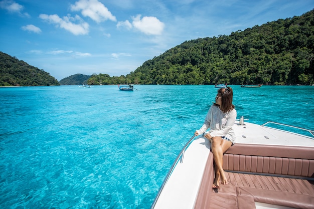 美しい女の子が頭のスピードボートに座って、スリン島の美しい海を見て、タイ