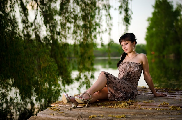 Beautiful girl sits at the lake