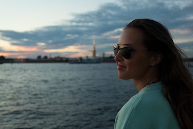 Beautiful girl sitting on the embankment.