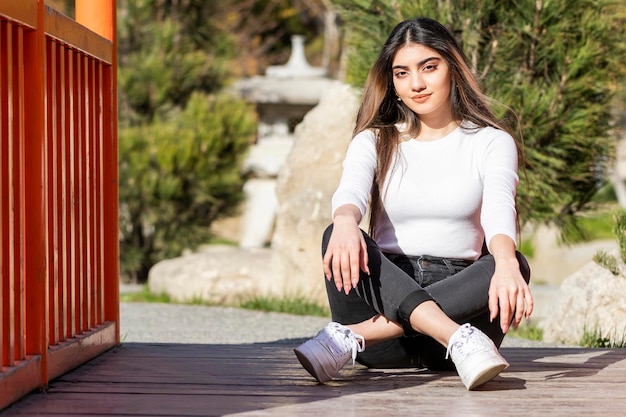 A beautiful girl sitting on the ground and looking at the camera High quality photo