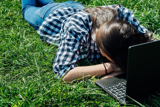 Beautiful girl sitting in the park with a laptop