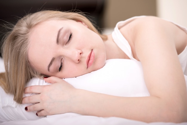 Bella ragazza dorme in camera da letto.