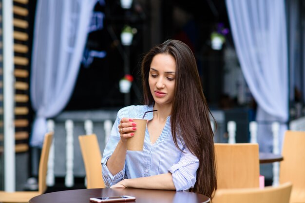 美しい少女の笑顔とコーヒーを飲みます。