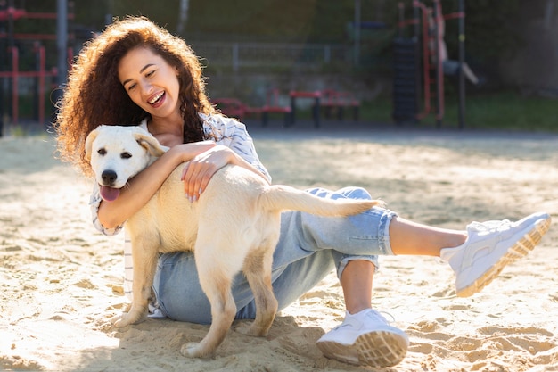 彼女の犬を抱きしめながら笑っている美しい女の子
