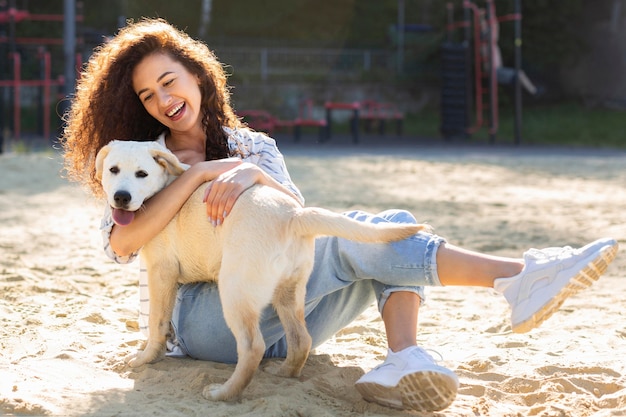 Photo beautiful girl smiling while hugging her dog