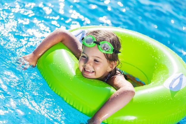 Beautiful girl in sport glasses at swimming pool in summer time