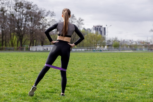 Bella ragazza in abiti sportivi che si esercita all'aperto