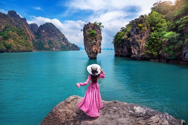 Photo beautiful girl standing on the rock at james bond island in phang nga, thailand.
