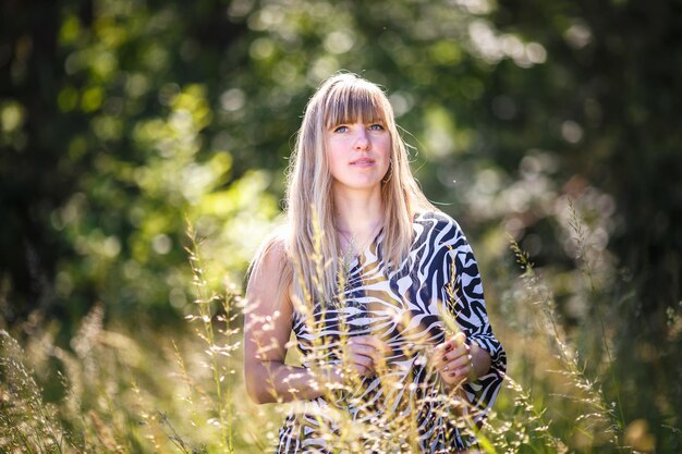 Beautiful girl stands in thicket of forest