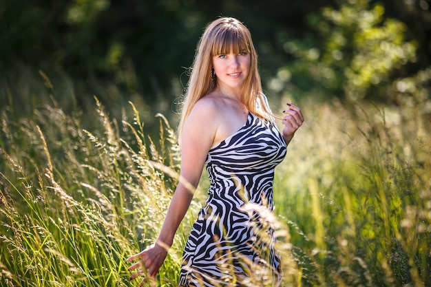 Beautiful girl stands in thicket of forest