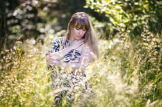 Beautiful girl stands in thicket of forest