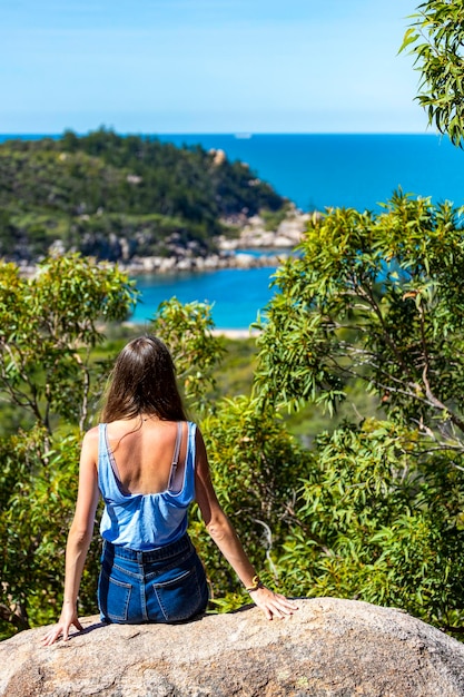 beautiful girl stands on top of mountain overlooking magnetic island, queensland, australia