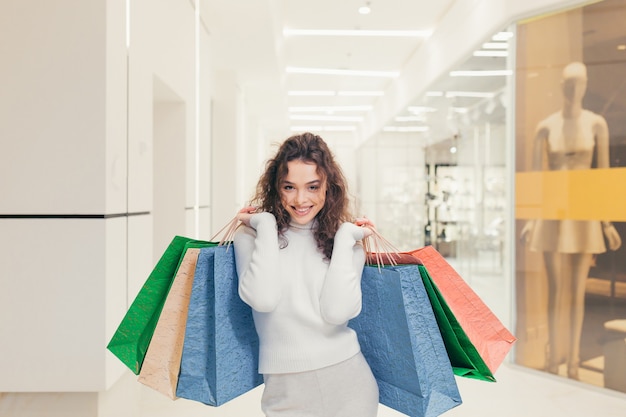 色付きのバッグを持つ店の美しい少女