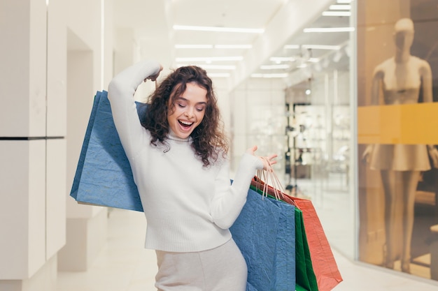 Beautiful girl in the store with colored bags