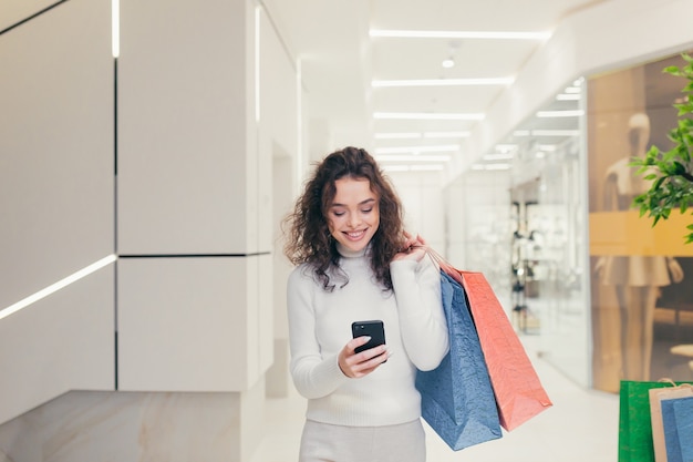 Beautiful girl in the store with colored bags