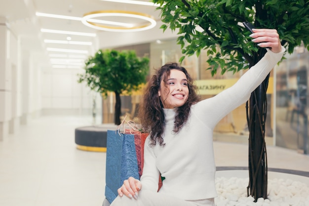 Beautiful girl in the store with colored bags