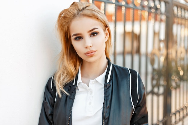 Beautiful girl student in jacket and polo shirt near college