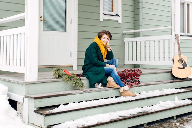 Photo beautiful girl in stylish clothes on a caryl at home