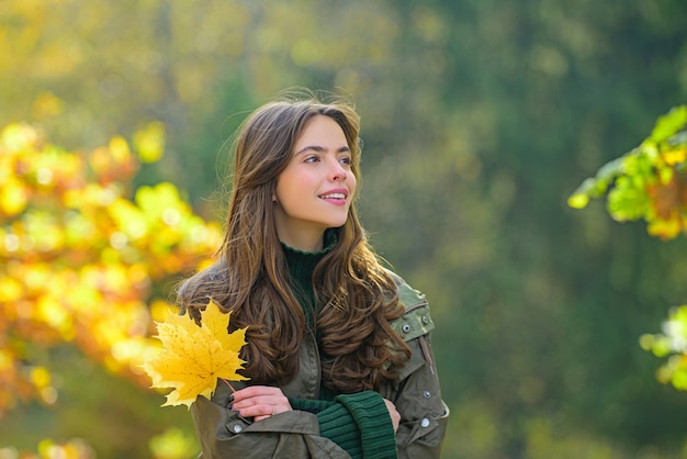 秋の公園でスタイリッシュなファッションの服を着た美しい少女。晴れた日に屋外で美しい女性。