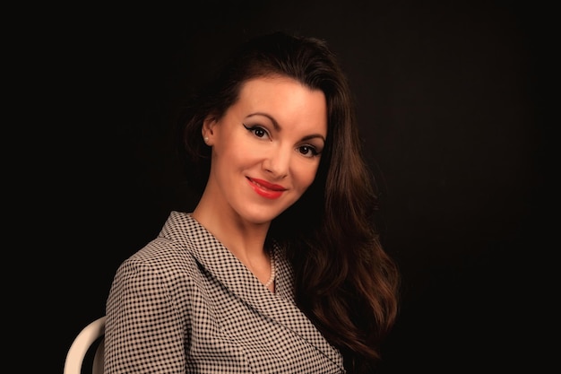 Beautiful girl in a suit on a dark background