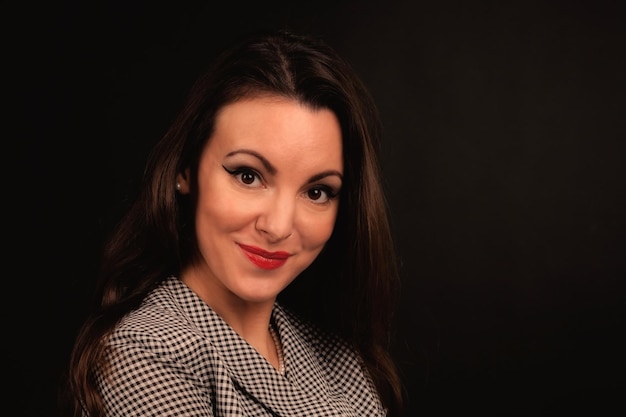 Beautiful girl in a suit on a dark background