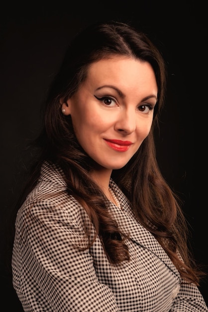 Beautiful girl in a suit on a dark background