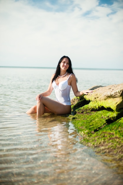 Beautiful girl sunbathing and swimming in the sea