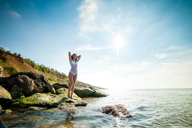 Beautiful girl sunbathing and swimming in the sea