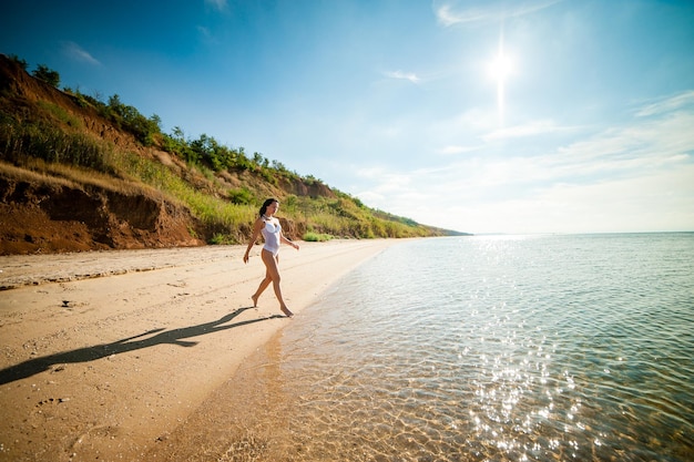 Bella ragazza che prende il sole e nuota nel mare