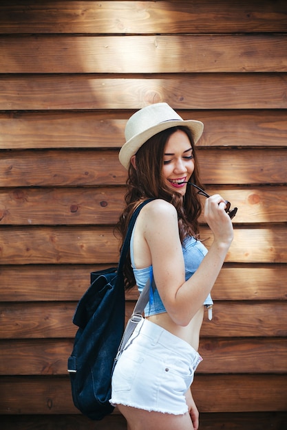 Beautiful girl in sunglasses posing on brown wall