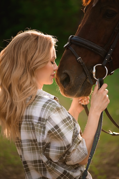 Photo beautiful girl together with her favorite chestnut horse.