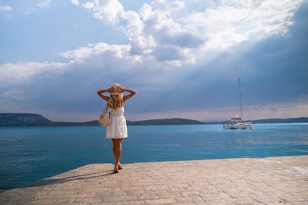 Beautiful girl tourist walking at ermioni marina seaport greece