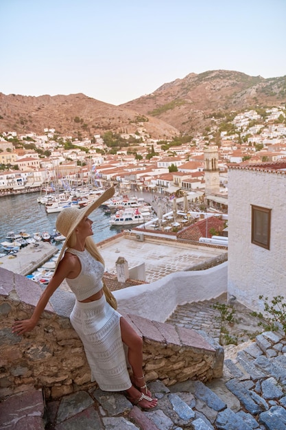 Красивая девушка-туристка гуляет по улицам гидры греции
