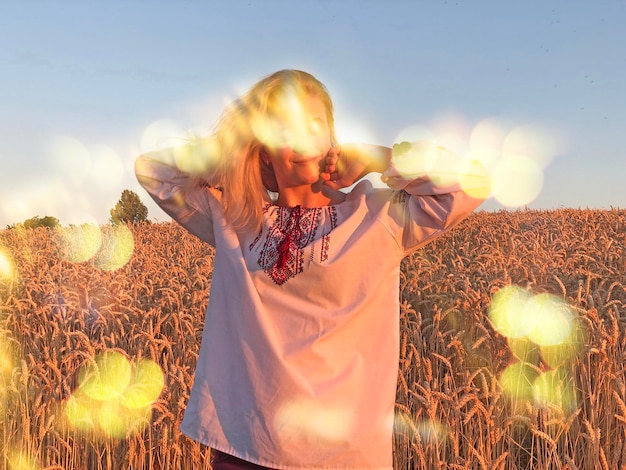 Beautiful girl in traditional Ukrainian clothes in a wheat field Beautiful girl in an embroidered shirt in a wheat field at sunset