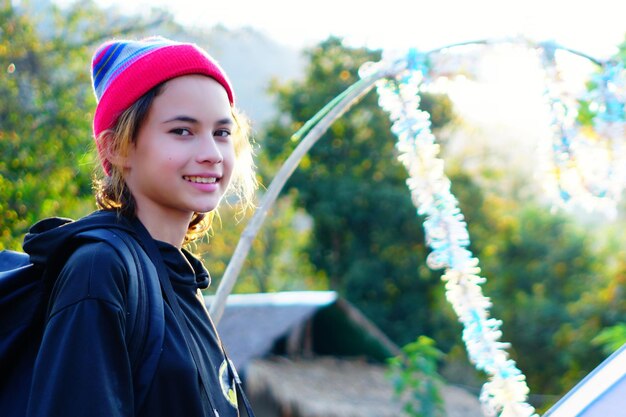 Beautiful girl traveling alone on summer vacation trip with backpack travelling recreation in a park with mountain thailand